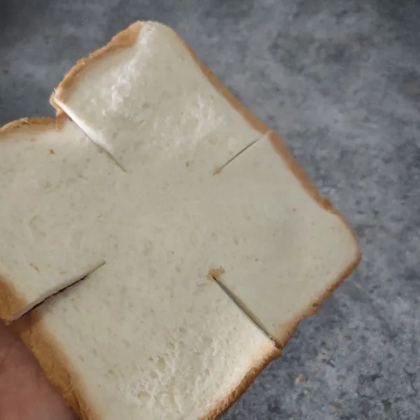 Pipihkan roti tawar lalu potong sedikit setiap sisinya.