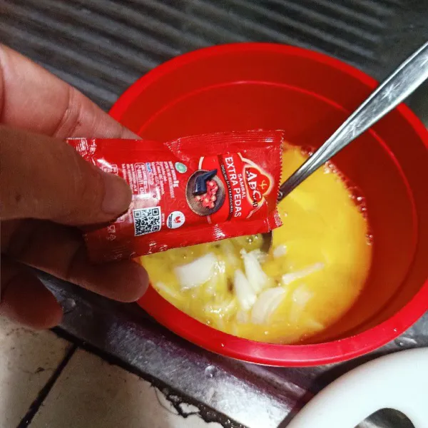 Masukkan bawang bombay kedalam mangkok telur. Lalu beri saus sambal.