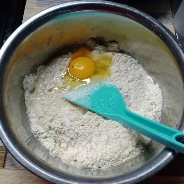 Dalam wadah masukkan terigu, susu bubuk, gula pasir dan ragi instan. Aduk rata. Kemudian masukkan telur dan air hangat, aduk dengan sendok sampai tercampur.