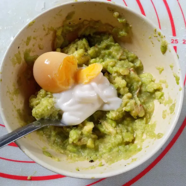 Pisahkan kuning dan putih telur rebus, masukkan kuning telur dan mayonnaise ke alpukat, hancurkan sampai lembut.