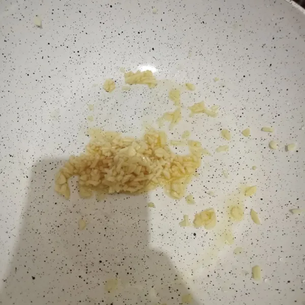 Tumis bawang putih hingga layu.