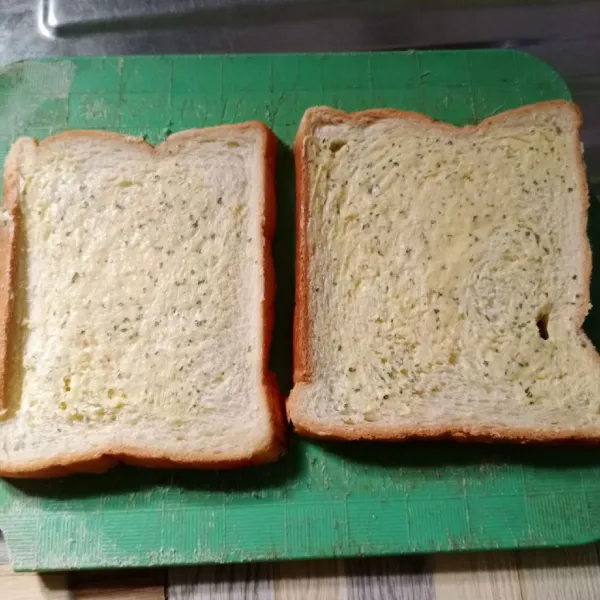 Oleskan campuran butter pada permukaan roti. Kemudian tumpuk roti menjadi satu.