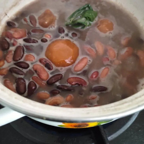 Masukkan kacang merah dalam panci, tambahkan secukupnya air dan 1 lembar daun pandan, rebus sampai empuk.