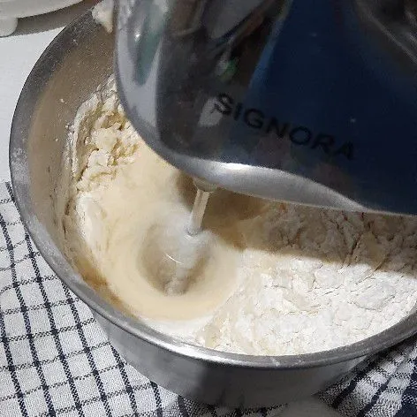 Lalu masukkan tepung, lebih baik mengaduk dengan spatula.