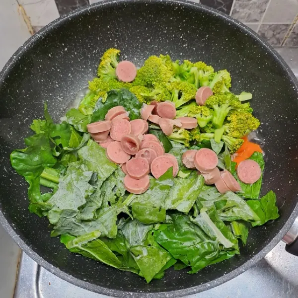 Masukkan sosis, daun brokoli dan brokoli. Aduk sampai rata dengan tumisan.