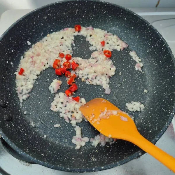 Tumis bawang merah dan bawang putih cincang hingga harum. Masukkan cabe, tumis hingga bau langunya hilang.