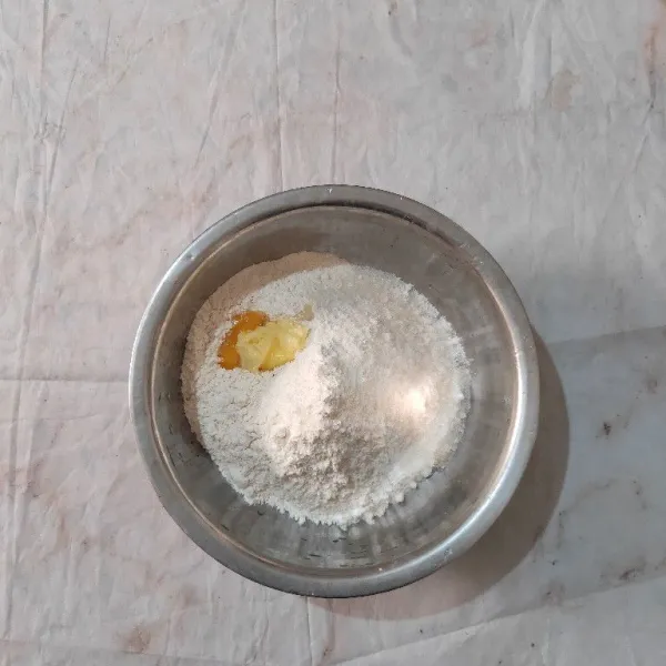 Dalam wadah, masukkan tepung terigu, gula pasir, kuning telur, margarin dan garam. Aduk rata.