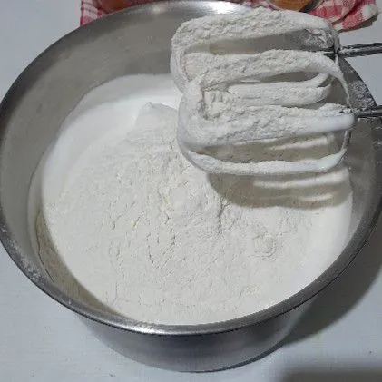 Kemudian masukkan tepung dan vanila bubuk,sambil diayak, mixer perlahan.
