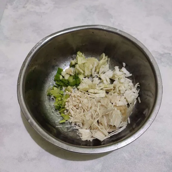 Masukkan kubis, jamur enoki serta daun bawang ke dalam bowl.