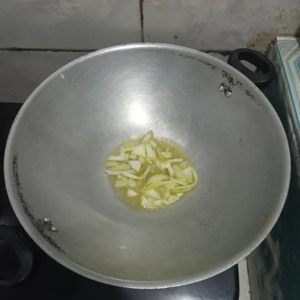 Tumis irisan bawang bombay dan bawang putih.