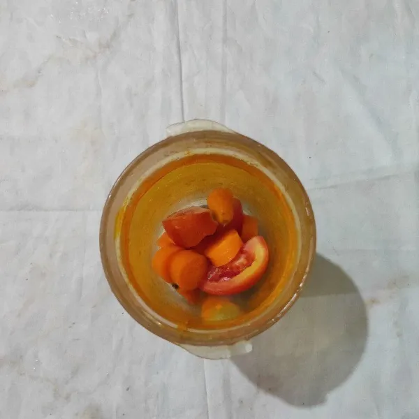 Masukkan potongan buah dan air perasan jeruk ke dalam blender. Proses hingga halus.