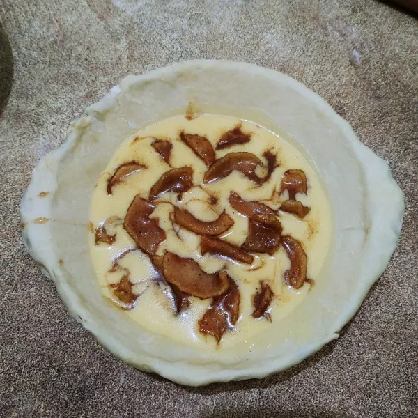 Siapkan kulit pastry, lalu ratakan didalam wadah tahan panas. Tuang adonan custard, lalu tata apel karamelnya.