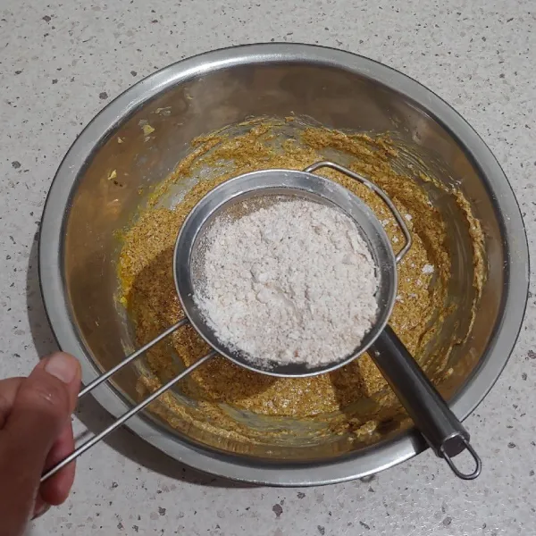 Ayak tepung terigu, baking powder, kayu manis bubuk dan rempah bubuk di atas adonan basah, beri garam.