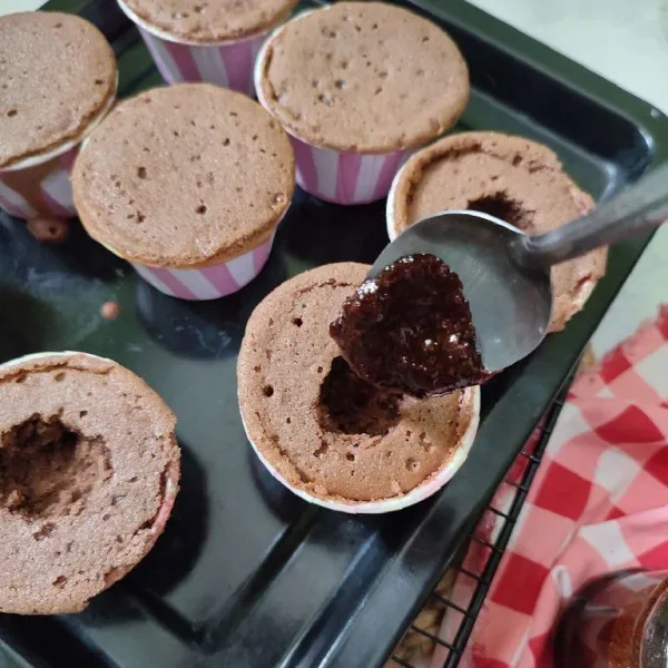 Setelah matang, keluarkan cupcake dari oven, tunggu hingga dingin, lalu bolongkan bagian tengah cupcake. Isi dengan saos karamel.