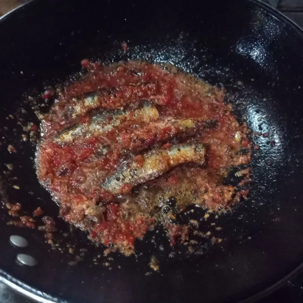 Masukkan ikan, aduk rata masak sampai matang, koreksi rasa.