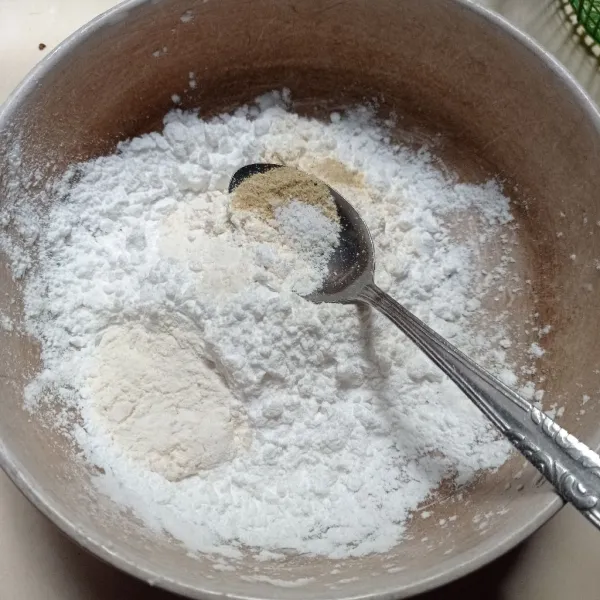 Masukkan tepung terigu, tepung tapioka, garam dan kaldu bubuk ke dalam wadah.