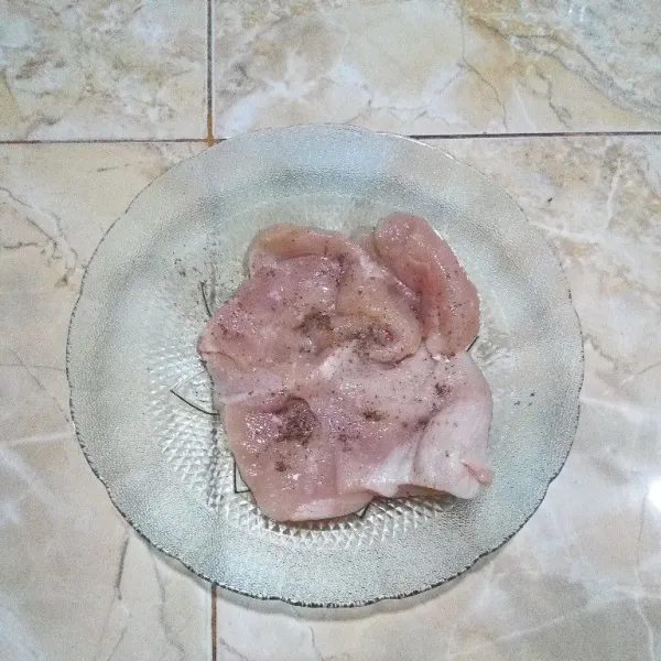Lumuri daging ayam dengan garam dan lada bubuk. Ratakan di kedua sisinya.