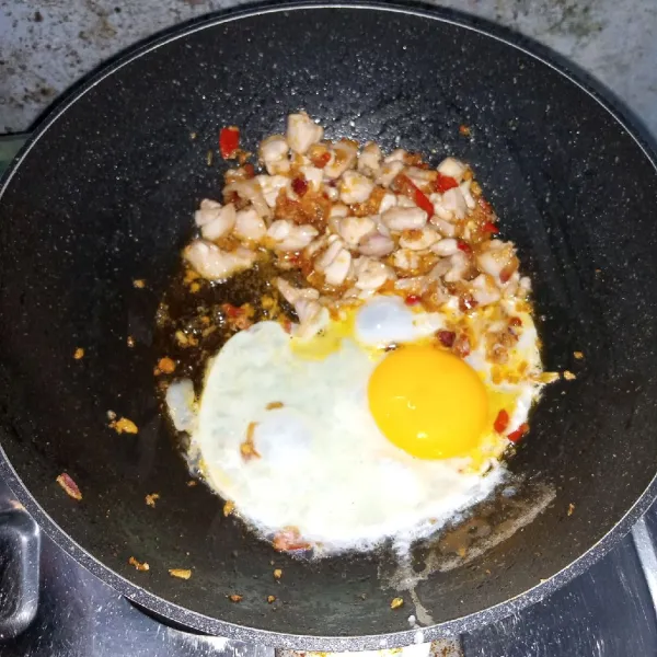 Masukkan ayam dan aduk rata. Masak sampai berubah warna. Kemudian tambahkan telur dan masak sambil di orak-arik.