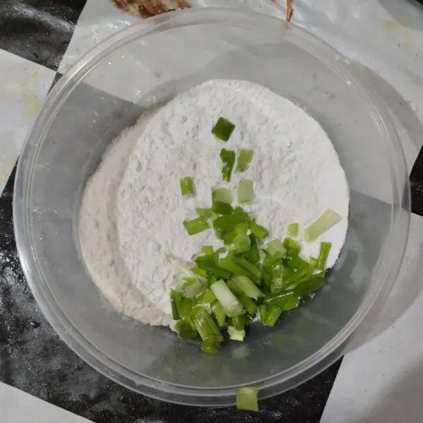 Campurkan tepung terigu, daun bawang, garam dan kaldu bubuk. Aduk rata.