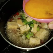 Set api kecil. Tuang kocokan telur di atas tahu. Tutup pancinya, kemudian masak selama 2 menit.