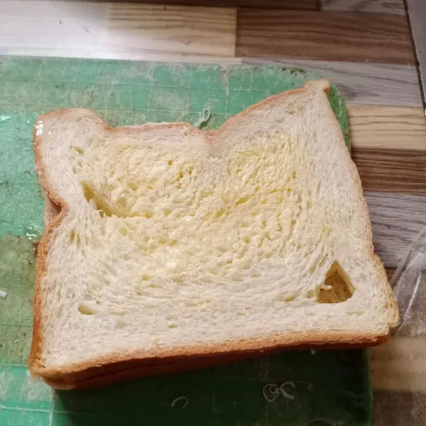 Olesi bagian atas dan bawah roti dengan margarin.