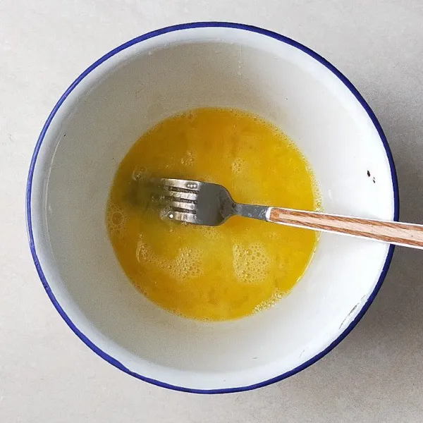 Di dalam mangkuk siapkan satu butir telur kocok lepas, lalu beri air soda dan kocok kembali.