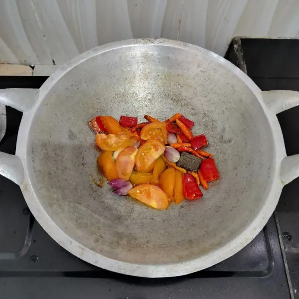 Panaskan minyak. Lalu goreng cabai merah, cabai rawit, bawang merah, bawang putih, terasi dan tomat hingga layu. Angkat.