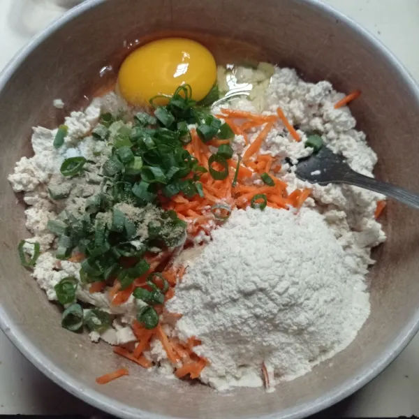 Lalu tambahkan tepung bumbu, telur, wortel, daun bawang, garam, lada bubuk, kaldu bubuk dan bawang putih bubuk.
