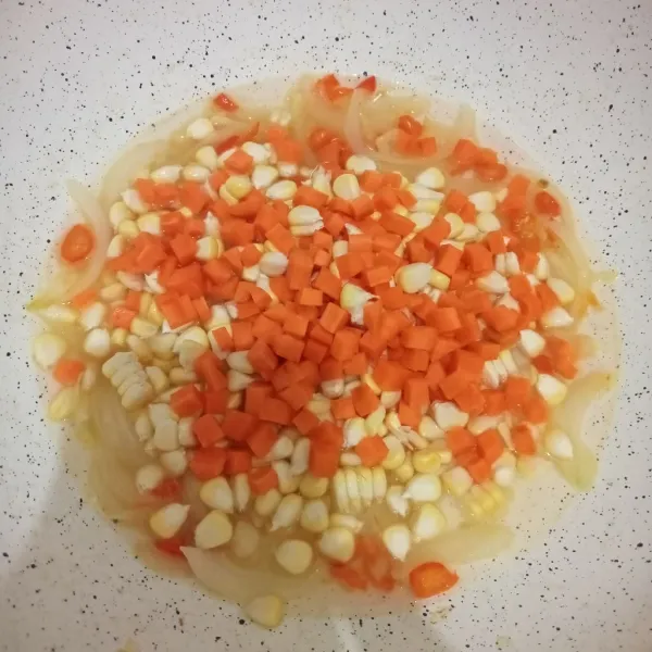 Tambahkan air dan masukkan wortel jagung. Masak hingga wortel setengah matang.