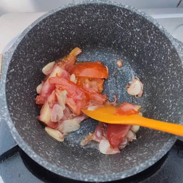 Panaskan minyak, tumis bawang merah dan bawang putih hingga harum dan layu. Masukkan tomat, tumis hingga layu.