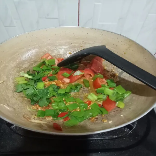 Masukkan tomat, daun bawang, seledri, cabe giling dan bawang putih giling, aduk rata.