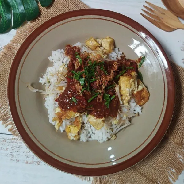 Tata nasi, beri tahu telur dan taoge rebus. Siram dengan bumbu kacang, taburi bawang merah goreng dan seledri.