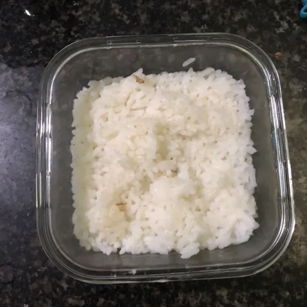 Tempatkan nasi putih di wadah tahan panas dan beri air.