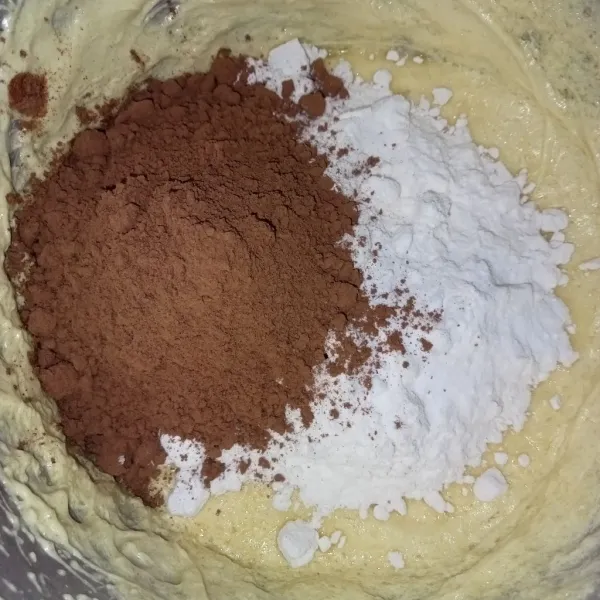 Masukkan tepung terigu, coklat bubuk dan soda sambil diayak dan mixer hingga rata.