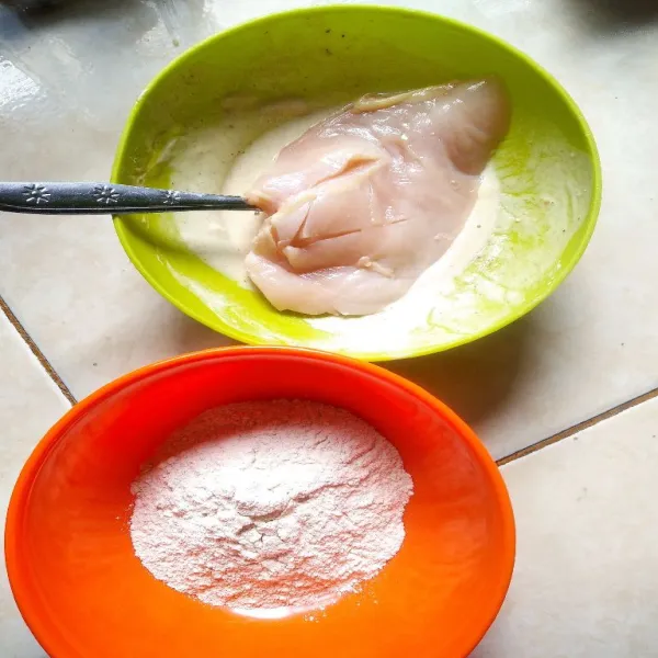 Ambil 3 sdm tepung serba guna, cairkan dengan 3 sdm air, celupkan ayam ke dalam tepung basah.