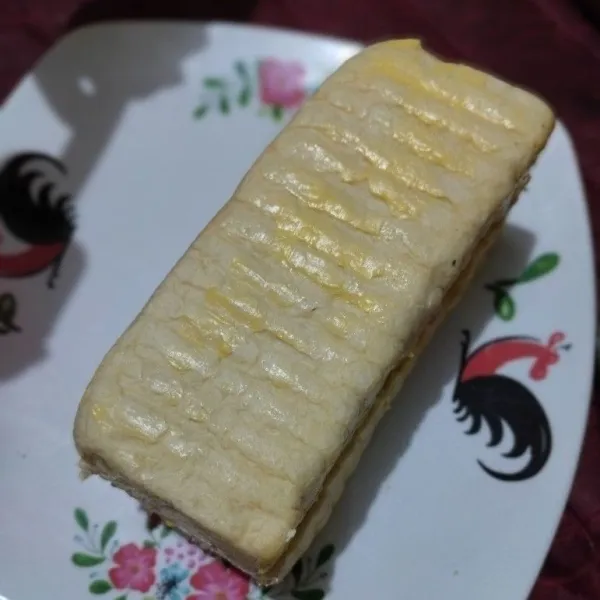 Olesi semua bagian roti dengan margarin.