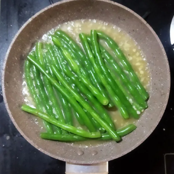 Tumis buncis bersama butter, sedikit air, kaldu bubuk, garam dan gula, masak hingga matang, angkat. Sajikan dalam piring saji, salmon panggang bersama saus lemon dan tumisan buncis.