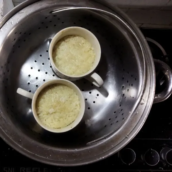 Kukus selama 45 menit. Angkat, sajikan nasi tim selagi panas dengan kuah kaldu dan rebusan pakcoy.
