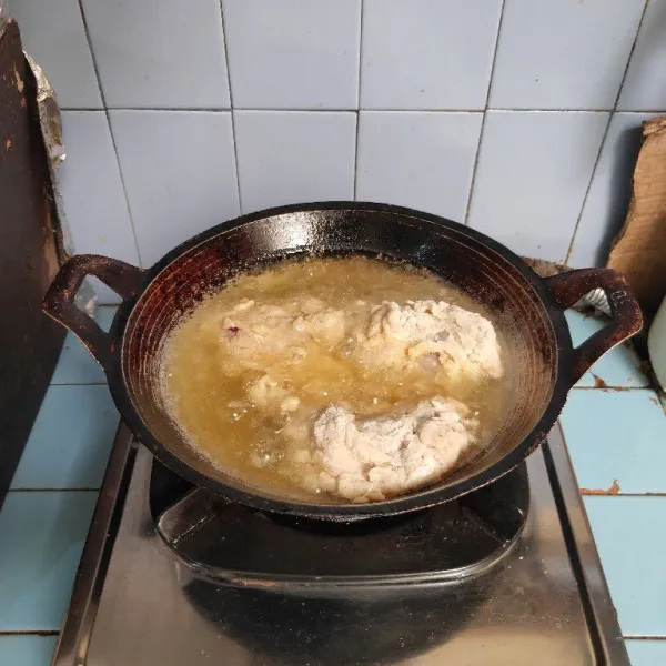 Goreng ayam dalam minyak panas hingga matang.