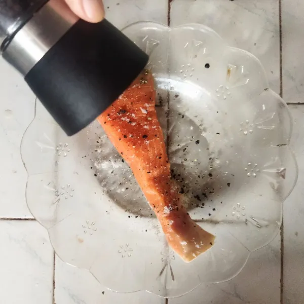 Keringkan salmon dengan tisue makan lalu bumbui dengan garam dan lada hitam.
