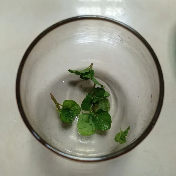 Remas daun mint, lalu masukan daun mint kedalam gelas saji.