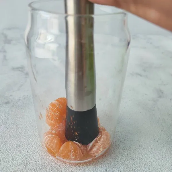 Masukkan jeruk kedalam gelas saji, tambahkan gula dan garam. Kemudian tekan-tekan sampai air sarinya keluar.