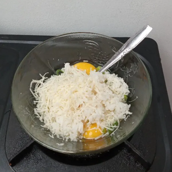 Masukkan telur, nasi, keju, daun bawang ke dalam mangkuk, aduk rata.