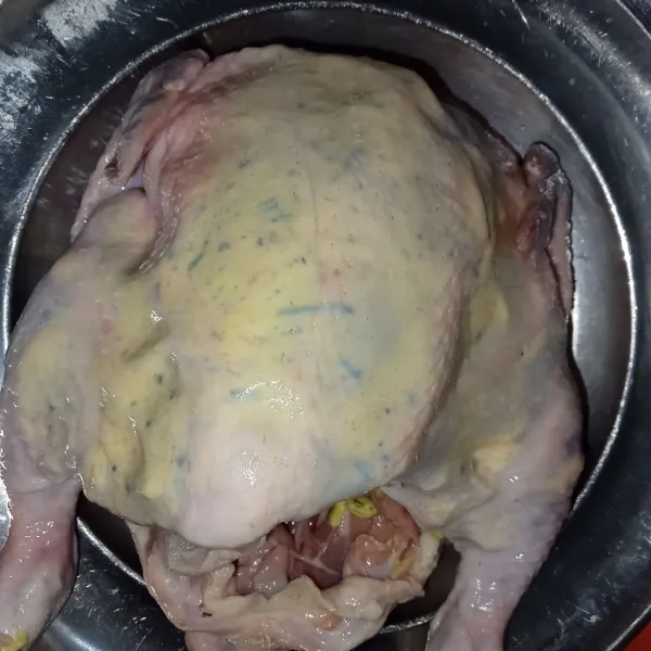Masukkan bumbu ke dalam ayam bagian bawah kulit lalu ratakan ke seluruh permukaan dalam ayam sampai ke paha ayam juga.