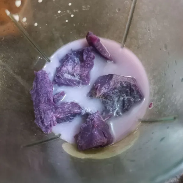 Haluskan ubi ungu kukus bersama susu cair dan air.