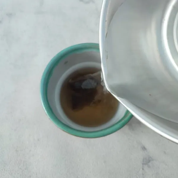 Seduh teh celup dengan air panas. Kemudian celup-celup sampai warna teh keluar.