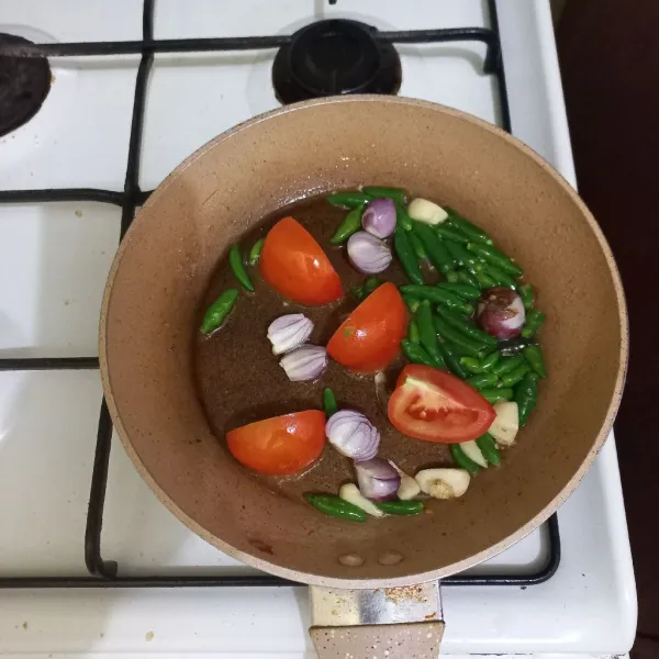 Goreng sebentar bawang merah, bawang putih, tomat dan cabe rawit hijau.