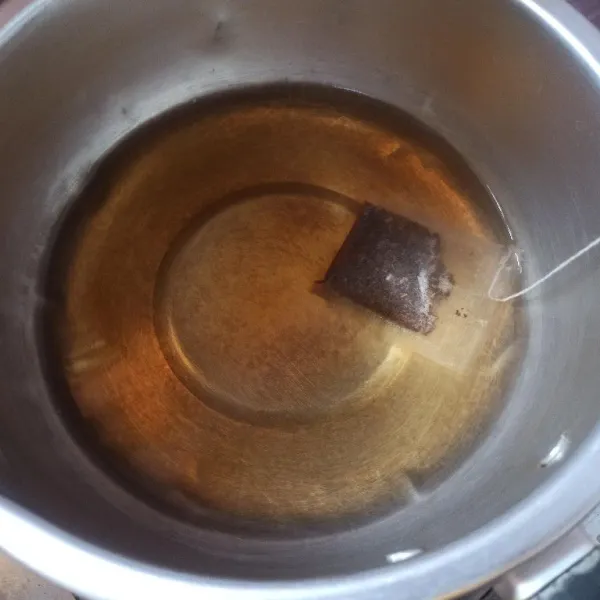 Setelah mendidih matikan api, masukkan teh celup, aduk-aduk hingga berubah warna.