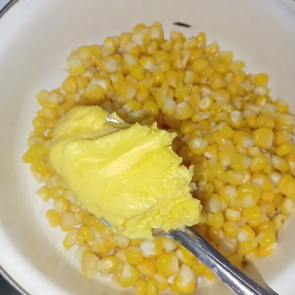 Pindahkan jagung ke dalam wadah lalu masukkan butter aduk rata.