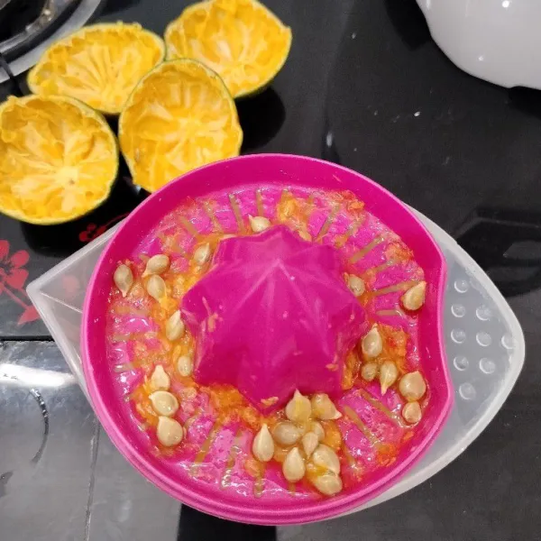 Belah jeruk melintang menjadi 2 bagian, lalu peras airnya.